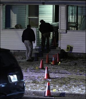 One of two slain men is removed from a home on E. Pearl St. in the Polish Village.