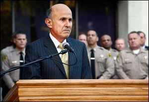 Los Angeles County Sheriff Lee Baca takes questions from the media after the FBI released results of a federal probe at a news conference in Los Angeles. 