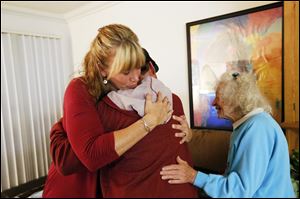 Veterinarian Dr. Mary Gardner, left, and neighbor Annie Kuzma, right, hug Mike Kelley after Gardner euthanized Kelley's cat 10-year-old Andy, at Kelley's home in Newport Beach, Calif. 