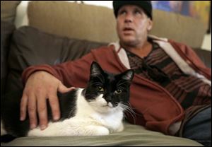 Mike Kelley strokes his 10-year-old cat Andy, on the sofa in his living room on the evening when veterinarian Dr. Mary Gardner came to euthanize the animal, in Newport Beach, Calif. A few weeks earlier, Andy didn't greet Kelley at the door as usual and was soon diagnosed with liver disease, which meant euthanasia.