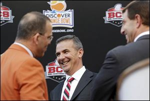 OSU’s Urban Meyer, center, and Clemson’s Dabo Swinney, right, have a laugh with Eric Poms, the Orange Bowl Committee’s CEO.