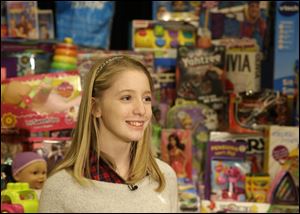 Savannah Day, 14, from Virginia, is interviewed near some of the over 4,000 toys Day and her sisters collected for Children's Hospital, Wednesday, Dec. 11, 2013, at the hospital in Cincinnati. Day is undergoing brain surgery at the hospital on Thursday.