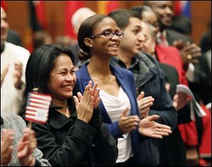 Nancy Padayogdog Hierholzer, left, formerly of the Philippines, and Tracey Annrose Hidalgo, formerly of Trinidad and Tobago applaud Thursday during a naturalization ceremony for 39 new U.S. citizens held at the Main Library downtown.