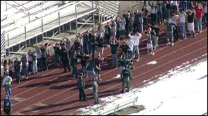 In this still image taken from video provided by Fox 31 Denver,  students gather just outside of Arapahoe High School as police respond to reports of a shooting at the school in Centennial, Colo.