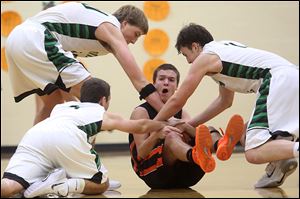 Gibsonburg’s Jordan Kreglow, center, attempts to keep possession of the ball as Ottawa Hills’s R.J. Coil, left, Ben Silverman and Geoff Beans surround him in Friday night’s game.