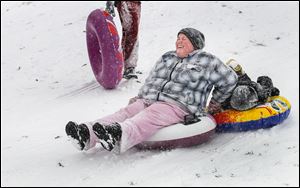 Toledoan Amanda Williams and her son Elijah, 6, ‘tube’ down the Wagener Sledding Hill at Side Cut Metropark in Maumee. Saturday’s snowfall reached 8 inches in Toledo and surrounding areas.