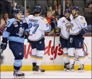 Toledo Walleye players Trevor Parkes (27) Martin Frk (19) and Max Nicastro (7) celebrate Frk's goal against Evansville IceMen during the first period.