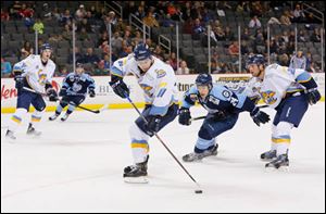 Toledo Walleye player Scott Arnold (11) picks up a loose puck against the Evansville IceMen during the second period.