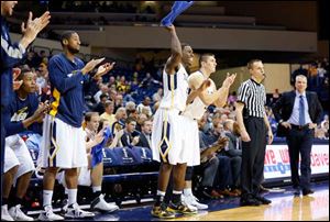 University of Toledo players cheer from the bench as the Rockets stretch their lead over Sam Houston State during the second half at Savage Arena, Saturday.