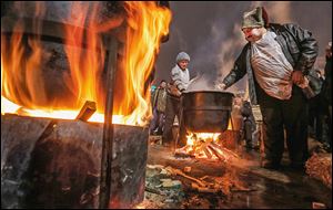Activists cook meals during a rally in the Independence Square in Kiev, Ukraine. About 200,000 anti-government demonstrators converged on the central square of Ukraine’s capital on Sunday. U.S. Sen. John McCain (R., Ariz.) spoke to the crowd.