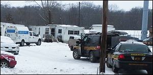 Wayne County sheriff's deputies secure the scene while investigators from the Ohio Bureau of Investigation search a mobile home in Wayne County's Green Township on Sunday.