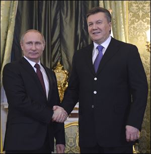Russian President Vladimir Putin, left, shakes hands with his Ukrainian counterpart Viktor Yanukovych during their meeting in Moscow today.