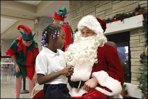 Laquantis Coker, a first grader at Rosary Cathedral tells Santa (Adam Hock) what she wants for Christmas during  St. John's Jesuit Jesuit High School & Academy's 15th annual Christmas on Campus on Dec. 4.