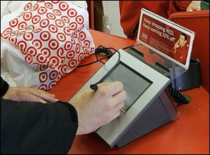 A customer uses a credit card at a Target store. The breach does not affect online purchases.