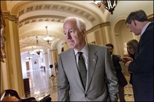 Senate Minority Whip John Cornyn, R-Texas, and other Republicans walk to a closed-door GOP meeting before the Senate moves to pass a modest, bipartisan budget bill, at the Capitol in Washington, Wednesday, Dec. 18, 2013.