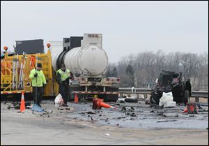 Emergency personnel investigate the scene of a fatal accident on the Ohio Turnpike north of Fremont on Jan 24, 2012. The State Highway Patrol says a tractor-trailer veered into a work zone on the turnpike, killing one worker and seriously injuring two others and the truck driver.