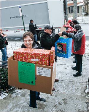 Volunteers unload a truck of holiday presents for  children at Family House in Toledo.