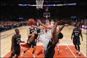 Ohio State’s Aaron Craft draws a foul against Notre Dame’s Eric Atkins during the first half Saturday night in New York. Craft finished with 10 points, three assists, and four steals.