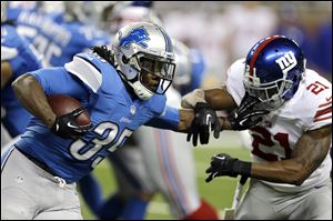 Detroit Lions running back Joique Bell tries to evade New York Giants free safety Ryan Mundy.