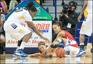UT's Ana Capotosto reaches for the ball as Dayton's Jodie Cornelie-Sigmundova falls over her. At left is UT's Brianna Jones. The  Rockets fell behind early and were never able to catch the Flyers.