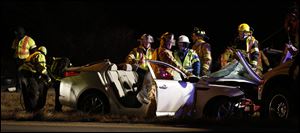 Rescue crews respond to a car accident on U.S. 20 at U.S. 6, on Monday, Dec. 23, 2013, in Fremont.