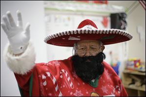 Pancho Claus, Rudy Martinez, waves to children as he visits Knowlton Elementary School, in San Antonio Friday. Pancho Claus, a Tex-Mex Santa borne from the Chicano civil rights movement in the late 1970s and early 1980s, is now an adored Christmas fixture in many Texas cities.