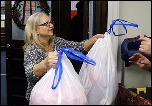 Pam Belew helps distribute bags of toys at the Helping Hands of St. Louis’ children’s Christmas party. Catholic Charities has been paying her rent  through the Permanent Supportive Housing program.