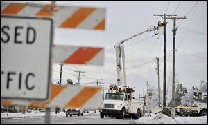 Crews work to restore power lines that were damaged along DeMille Road in Lapeer, Mich. on Monday, Dec. 23, 2013, after the ice storm over the weekend. (AP Photo/Detroit News, Robin Buckson)