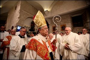 Latin Patriarch of Jerusalem, Fouad Twal, leads the midnight Christmas mass at the Church of Nativity, traditionally believed by Christians to be the birthplace of Jesus Christ, in the West Bank town of Bethlehem on Christmas Eve.