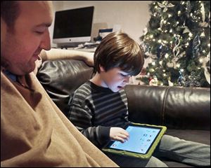 Adam Cohen watches as his son Marc, 5, uses a tablet at their home in New York. Mr. Cohen says apps have been a key part of Marc’s education.