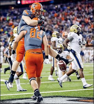 Bowling Green’s Alex Bayer is hugged by teammate Tyler Beck after scoring a touchdown against Pitt. Bayer finished with three catches for 57 yards in the loss for the Falcons.