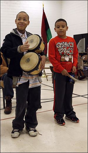 Antonio Moore Oxner, 11, left,  and Tristan Headrick, 7, play instruments as part of the festivities. The cele-bration continues today.