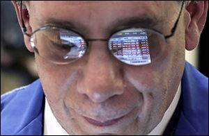 Trader Sal Suarino’s glasses reflect numbers on the New York Stock Exchange, where the Dow set a record in March.