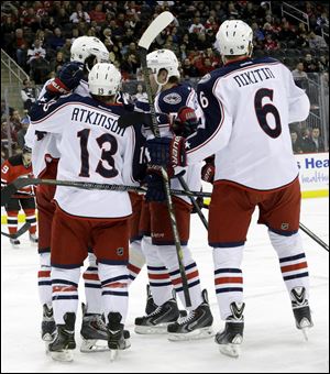 Columbus Blue Jackets center Artem Anisimov, top left, of Russia, is congratulated by teammates Cam Atkinson (13), Jack Johnson (7) and Nikita Nikitin (6), of Russia, after Anisimov scored a goal during the first period Friday in Newark, N.J. 