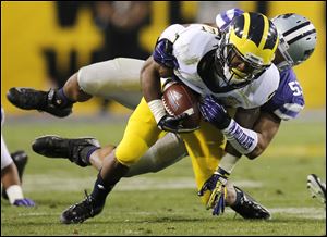 Michigan wide receiver Dennis Norfleet, front, is tackled by Kansas State linebacker Blake Slaughter during the first half.