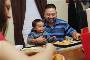 Rojelio Sanchez feeds his son Rojelio III, 2, with his daughter Karina, 18, at the family’s home in Napoleon. Since being released from prison in 2011, Sanchez has made it his goal to provide a better life for his family.