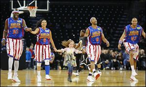 Andersyn Cummings, 5, of Elmore takes the court with the Harlem Globetrotters during their appearance at the Huntington Center.