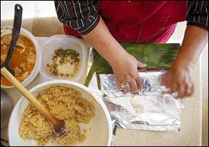 Finished tamales are wrapped as Dora Gonzales and her daughter, Cynthia, prepare traditional Salvadoran tamales from an ancient family recipe.