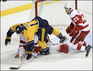 Nashville Predators forward Nick Spaling (13) falls over Detroit Red Wings goalie Jimmy Howard after stopping a shot by Spaling while being defended by Red Wings defenseman Brian Lashoff (23) in the second period.