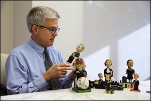 Ross Davies, professor of law and editor of The Green Bag, a law journal, holding one of the bobbleheads of Supreme Court justices he helped to design for The Green Bag, in Washington. 