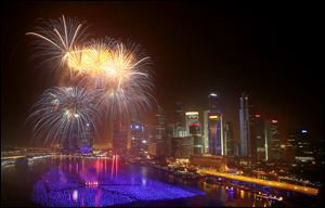 Fireworks explode over the financial district at midnight, Wednesday in Singapore. Celebrations started on New Year's Eve where concerts were held and thousands gathered on the streets to usher in the Year 2014. 