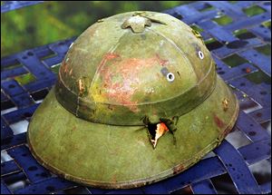 Damaged and dented, this North Vietnamese helmet that John Wast found on a battlefield in 1968 reminds him of his service in Vietnam. Markings inside helped locate the slain soldier’s family.