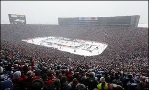 Hockey fans stand during the national anthems before the Winter Classic outdoor NHL hockey game between of the Toronto Maple Leafs and the Detroit Red Wings at Michigan Stadium in Ann Arbor today.