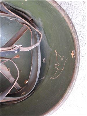 A dove in feathered flight is inscribed on the pith helmet that John Wast picked up on a battlefield.