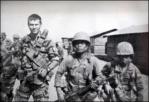 John Wast, a Green Beret sergeant in Vietnam, is pictured with Montagnard soldiers in 1968. He served with the 5th Special Forces Group in the Central Highlands.