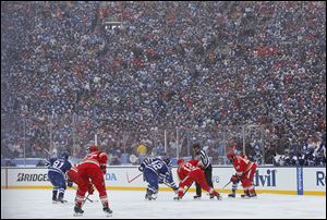 The Maple Leafs and the Red Wings face off during the first period of the Winter Classic in front of a reported 105,491 fans.