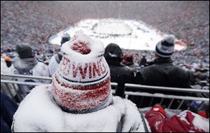 A Red Wings fan, coated with snow, watches during the third period. The Red Wings scored with less than six minutes remaining to force overtime, but lost in the shootout, 3-2.