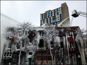 Firefighters work the scene where a fire engulfed several apartment units in the Cedar Riverside neighborhood, in Minneapolis, Wednesday.