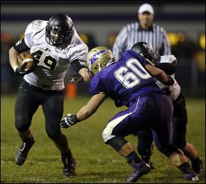 Perrysburg RB Mark Delas (49) runs the ball against  Maumee  OL Dakota Yeary (60) during a football game Friday, Nov. 1, 2013, in Maumee.