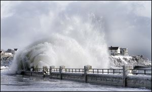 Heavy surf breaks over the seawall after a winter storm in Hampton, N.H. Some cities in the New England region reported having accumulations of more than 2 feet of snow as of Friday.